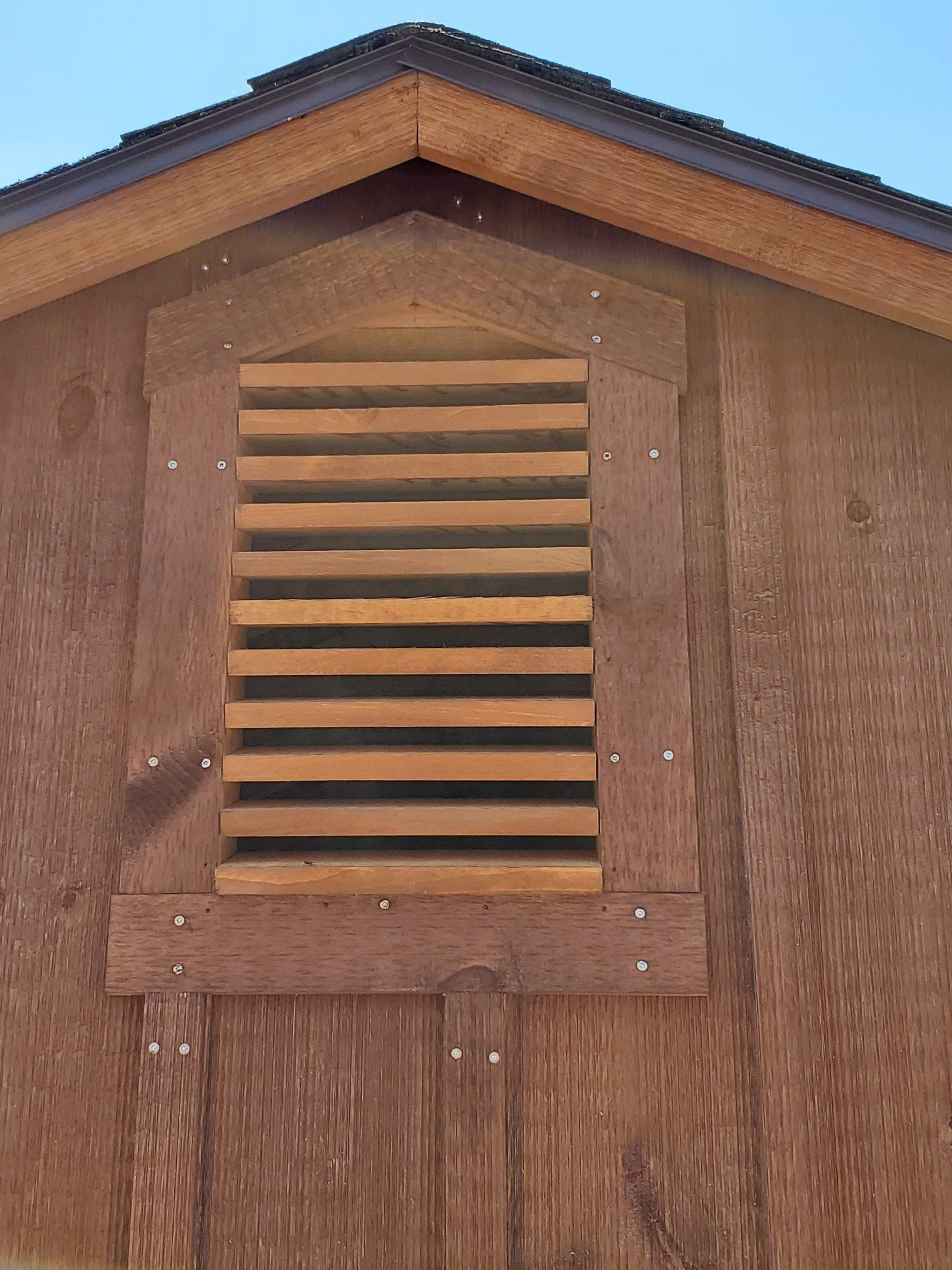 A wooden shed with a window and a roof