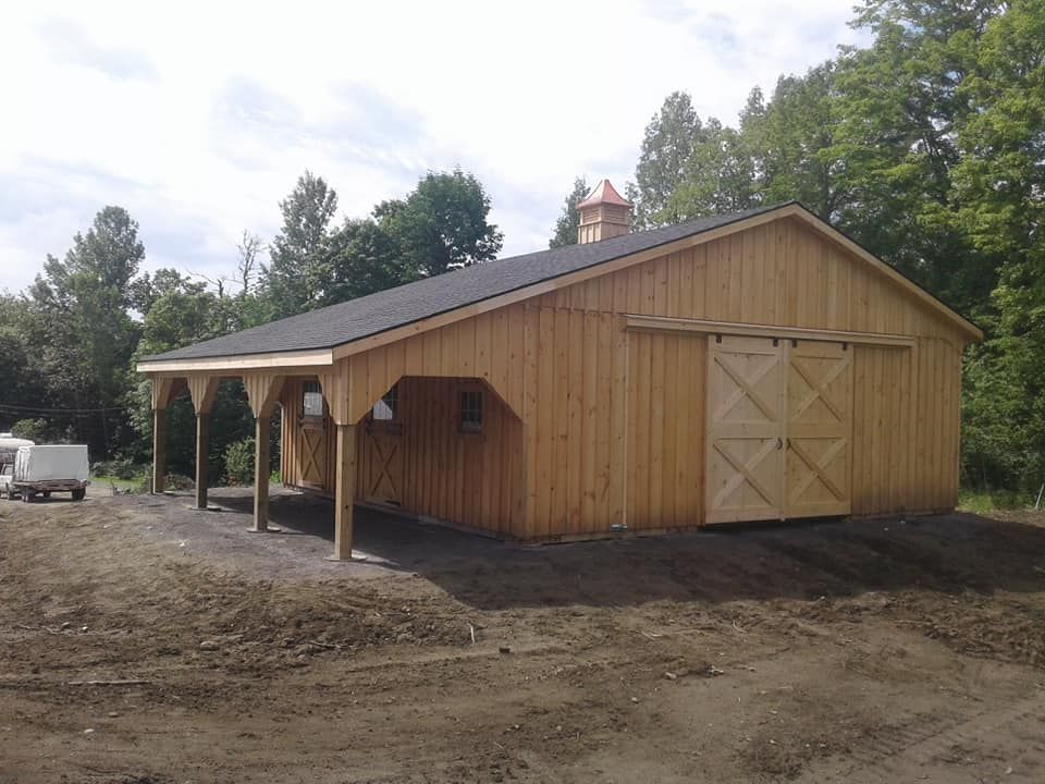 A large wooden barn with a sliding barn door