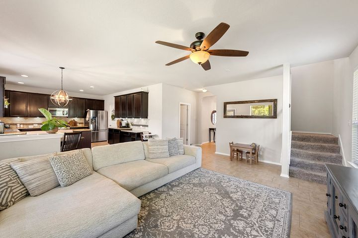 A living room with a couch , rug and ceiling fan.