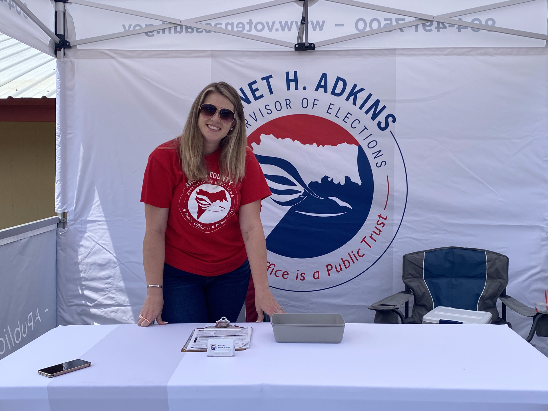 A woman standing in front of a net h. adkins sign