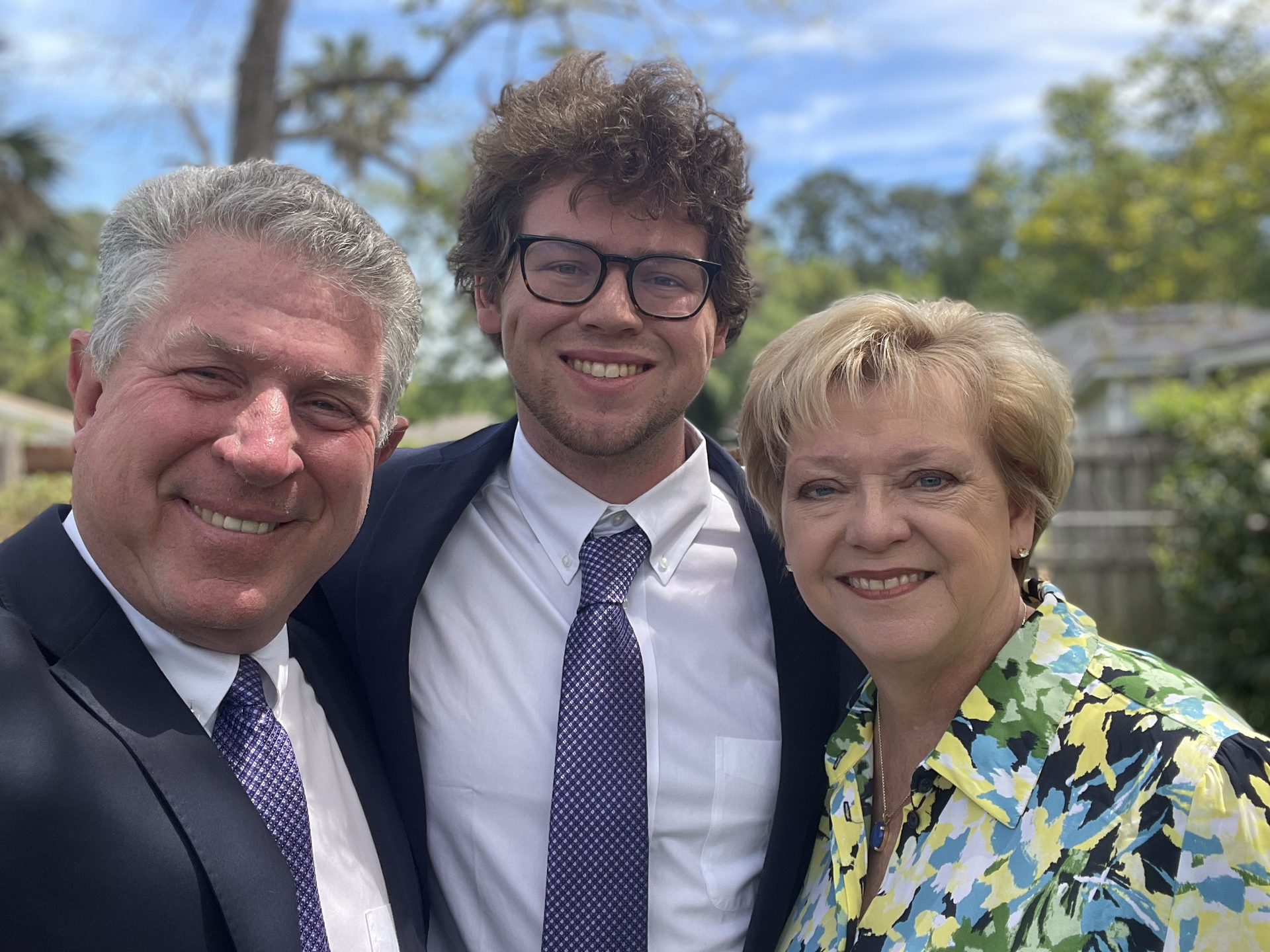 A man in a suit and tie is posing for a picture with two women.
