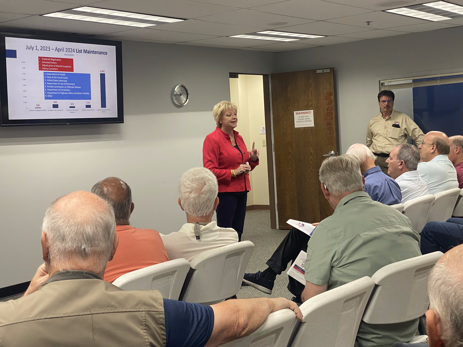 A woman is giving a presentation to a group of people