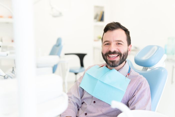 man sat in dentist chair smiling