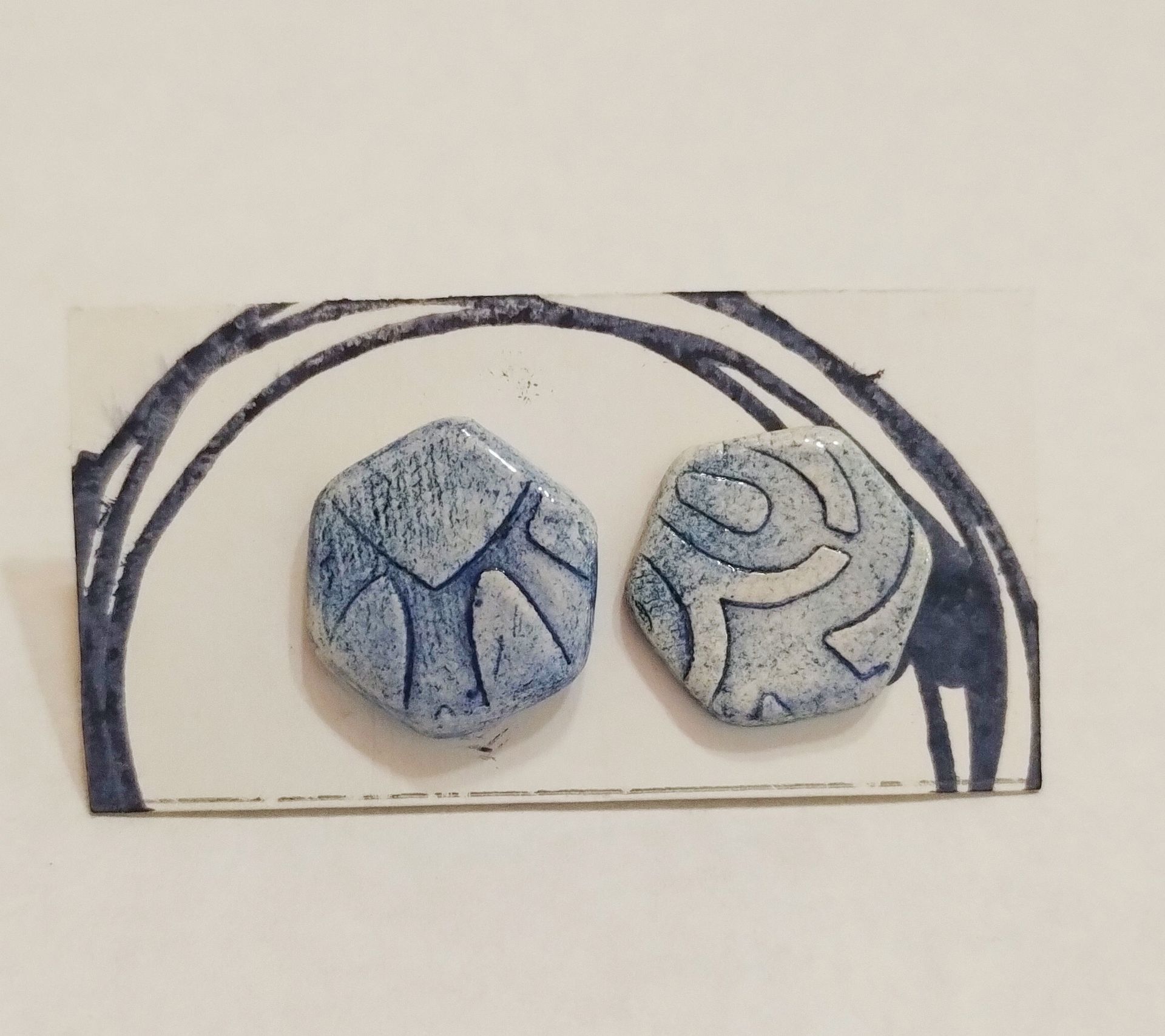 Un par de pendientes azules y blancos en una tarjeta.
