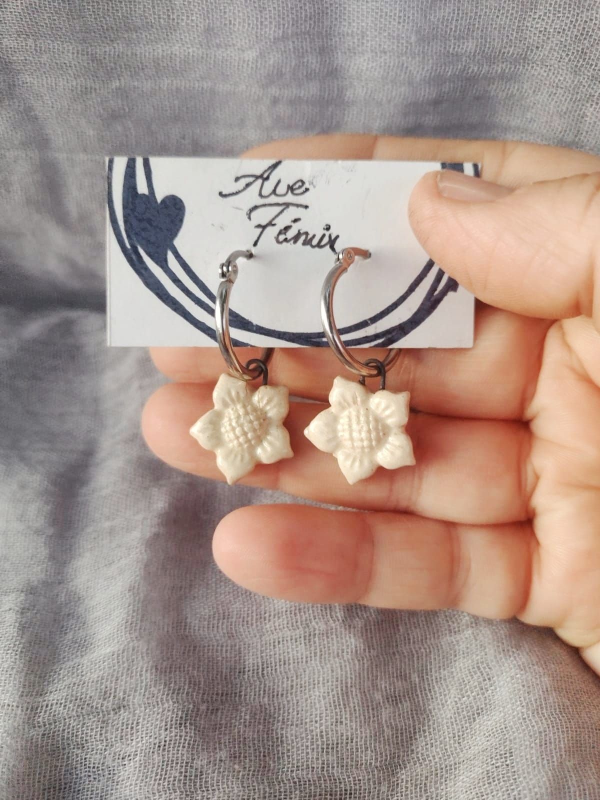 Un par de pendientes están colocados encima de una hoja verde.