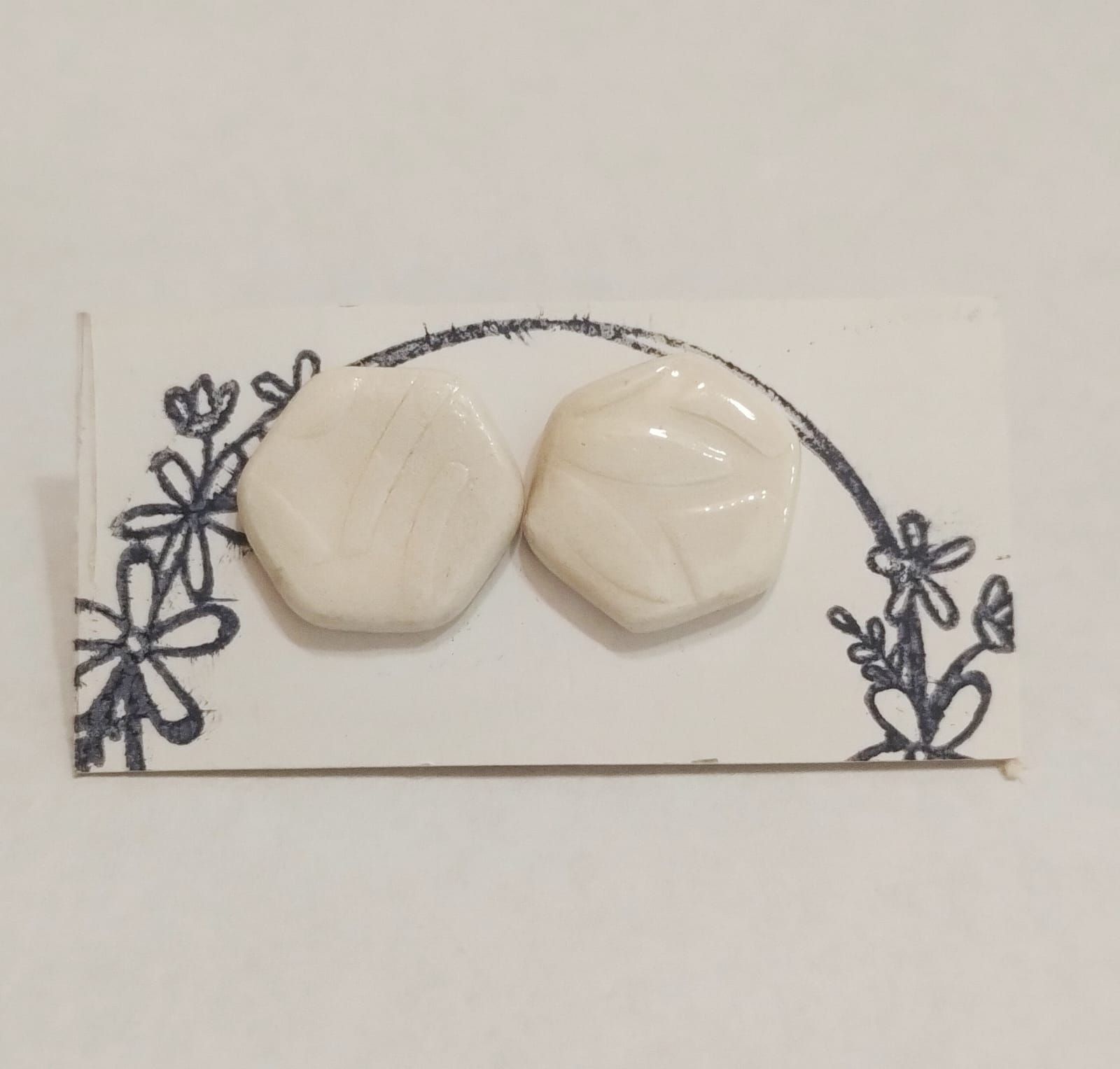 Un par de pendientes azules y blancos en una tarjeta.