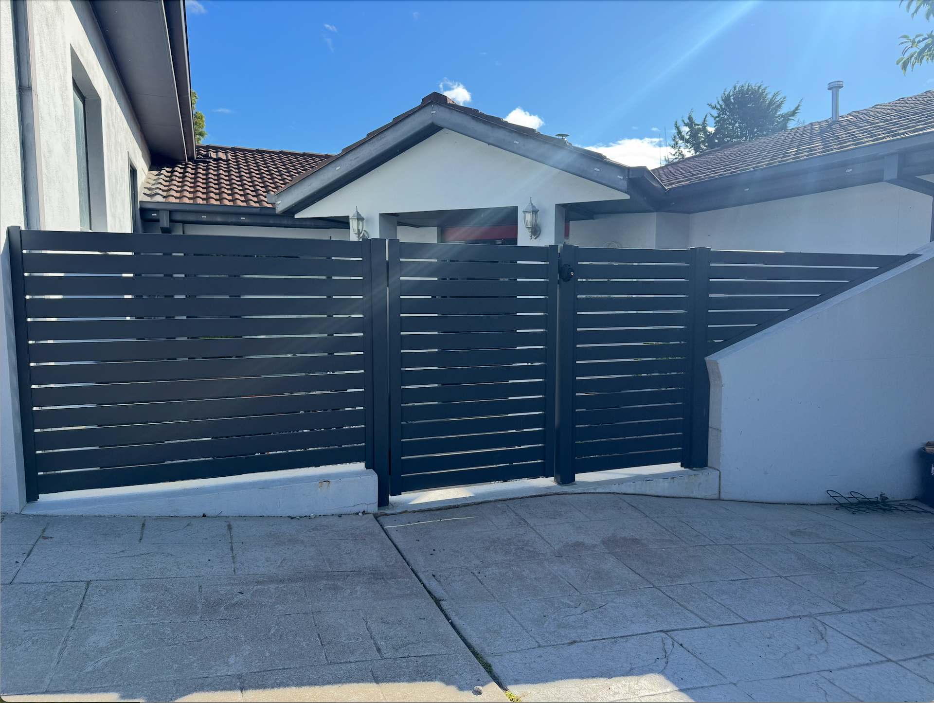 A house with a balcony and a wooden fence in front of it.