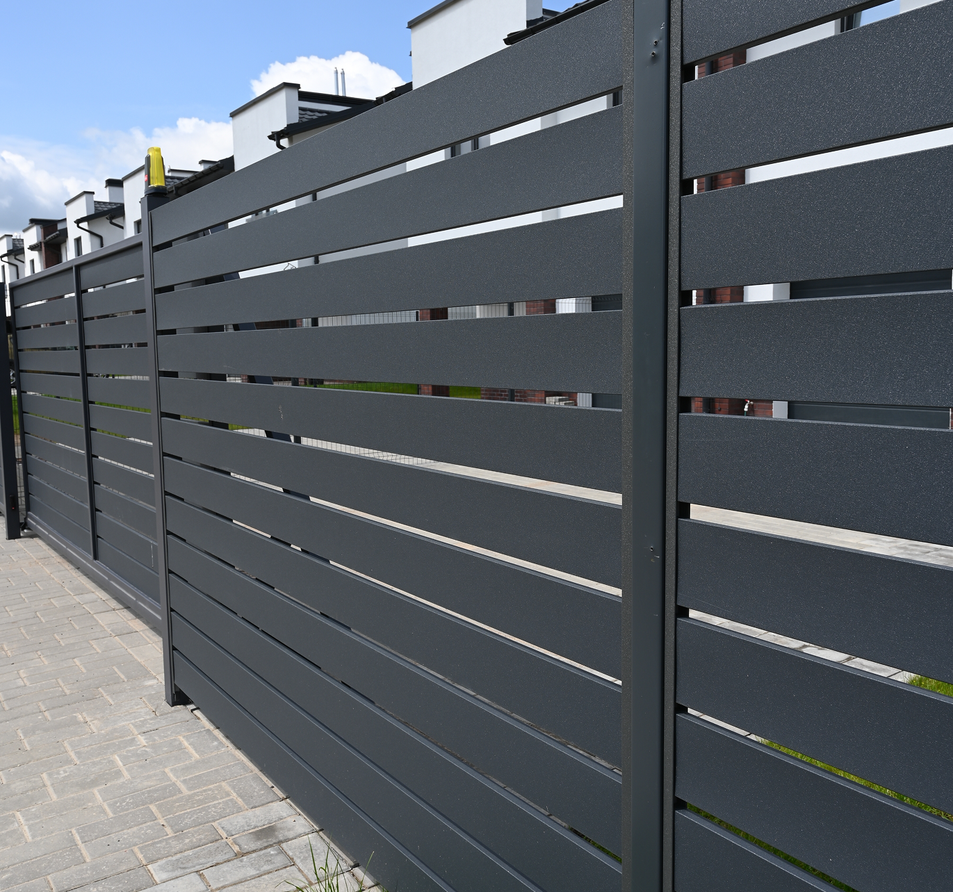 A close up of a black fence on a sidewalk