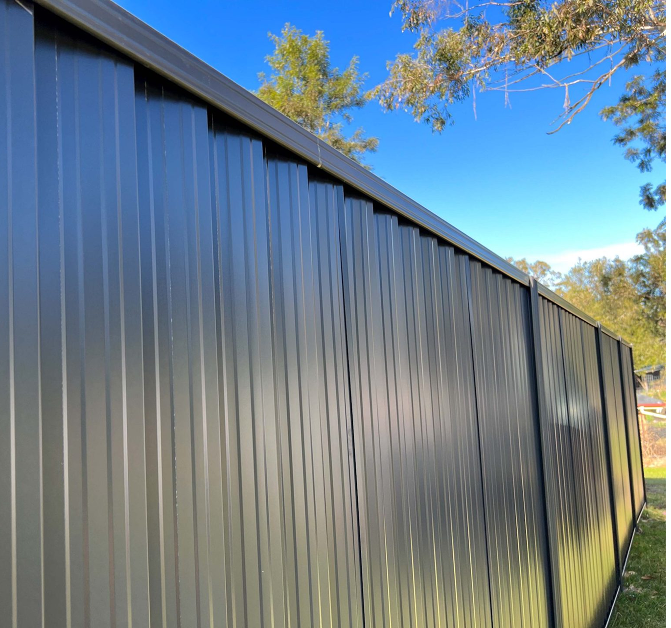A black fence with a blue sky in the background