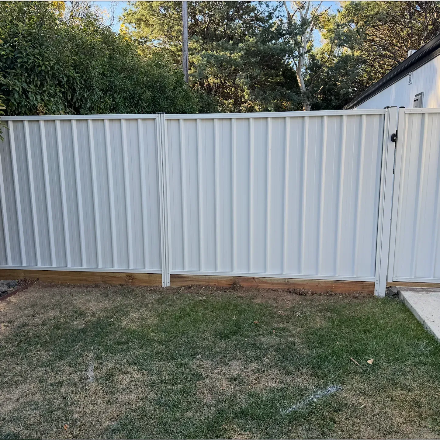 A house with a balcony and a wooden fence in front of it.