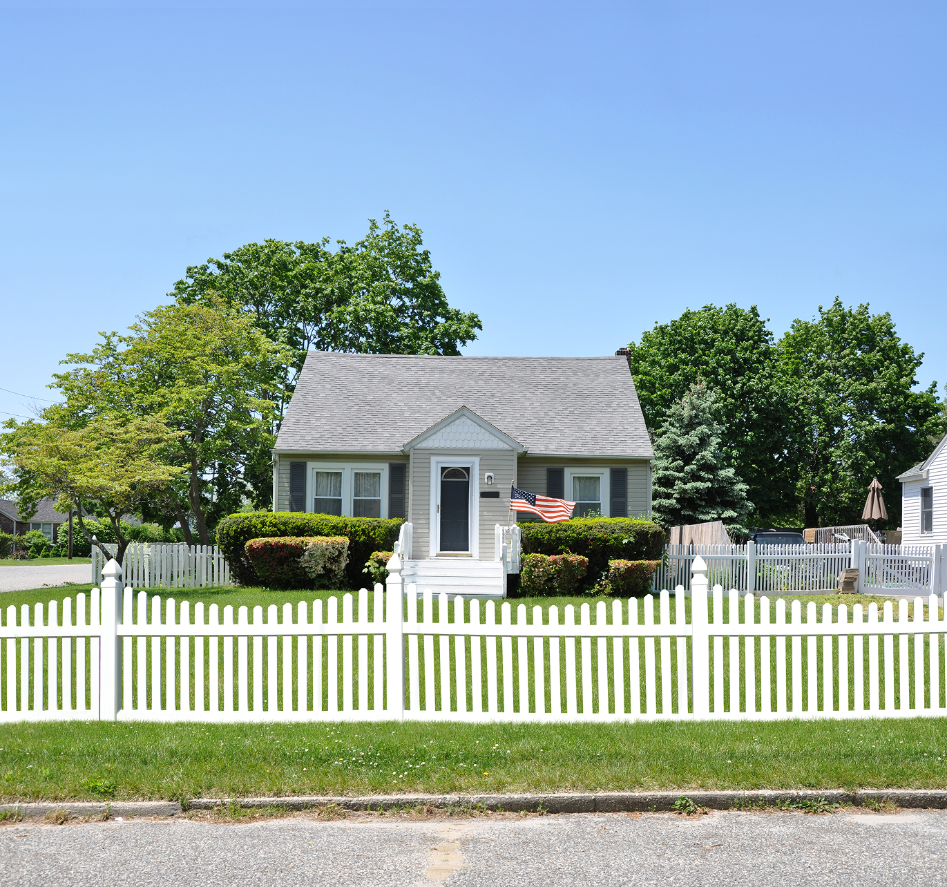 A small house with a white picket fence in front of it