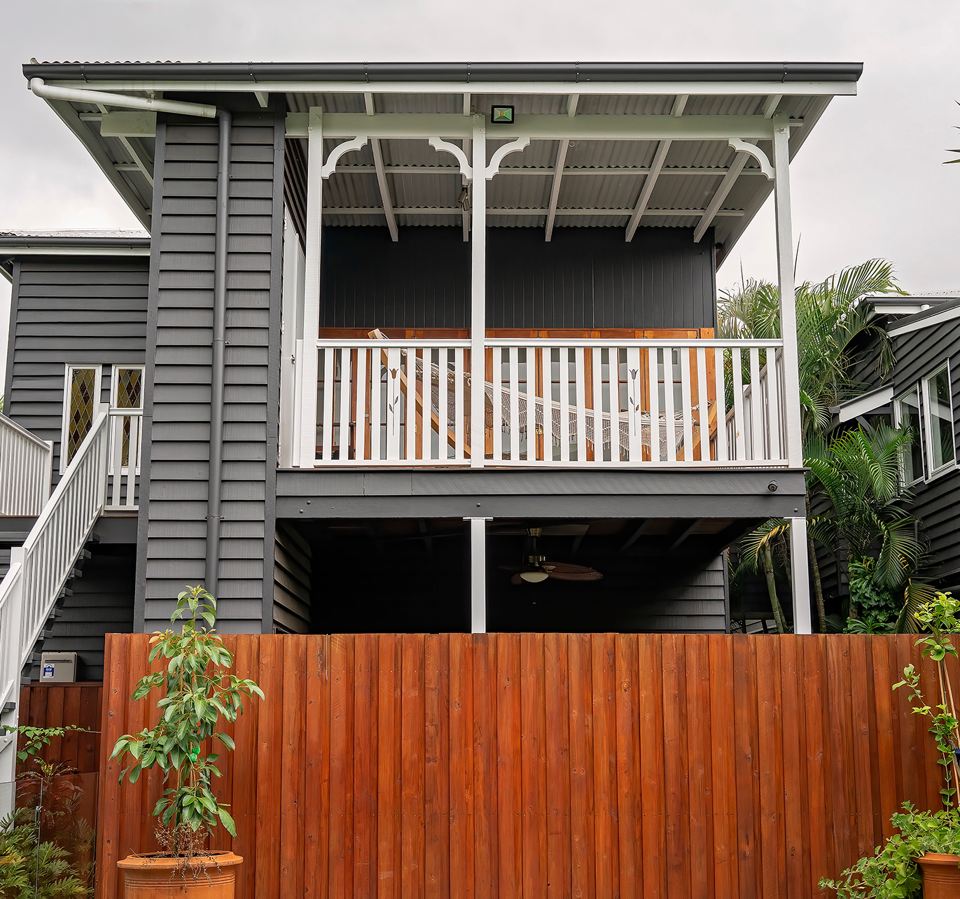A house with a balcony and a wooden fence in front of it.