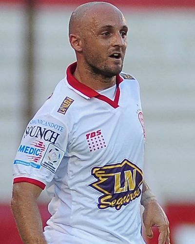 Jugador de fútbol con camiseta blanca y cuello rojo