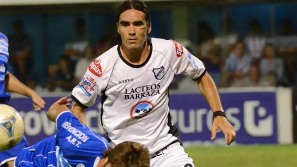 Jugador de fútbol con camiseta granate de Yamaha celebrando con el puño en alto.