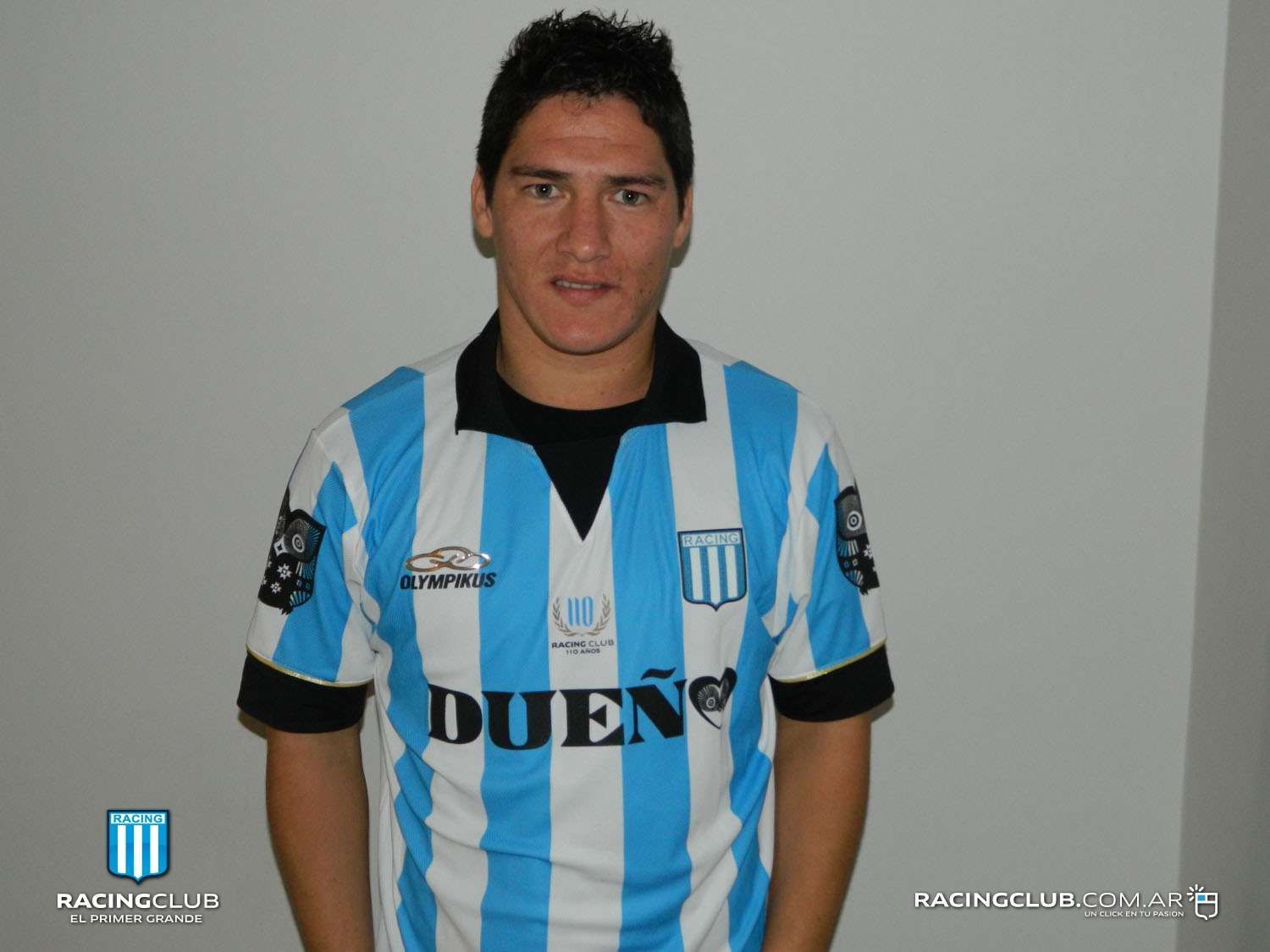 Hombre con camiseta de fútbol a rayas celeste y blanca, cuello y mangas negras;