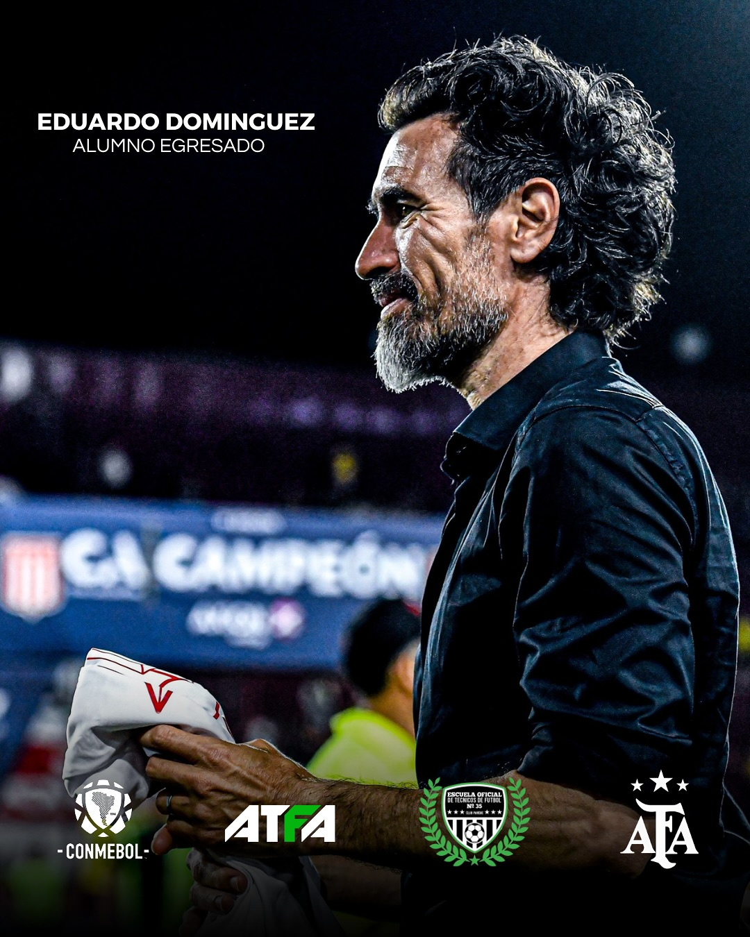Eduardo Domínguez, entrenador de fútbol, mirando hacia un lado, vistiendo una camiseta oscura, sosteniendo una toalla.