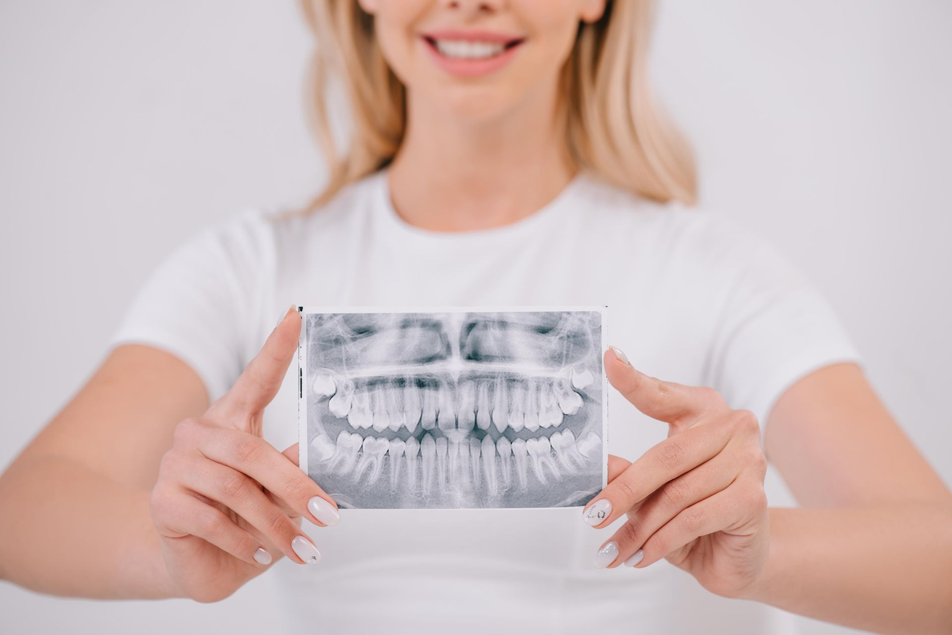 Happy elderly man admiring his new dental implants in a mirror