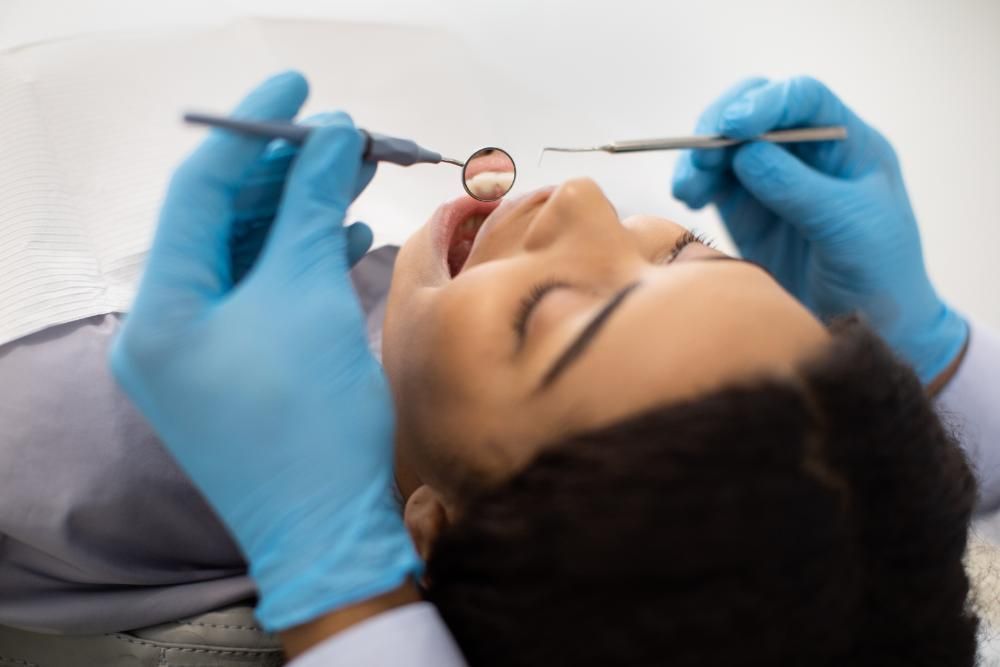 A woman is getting her teeth examined by a dentist.