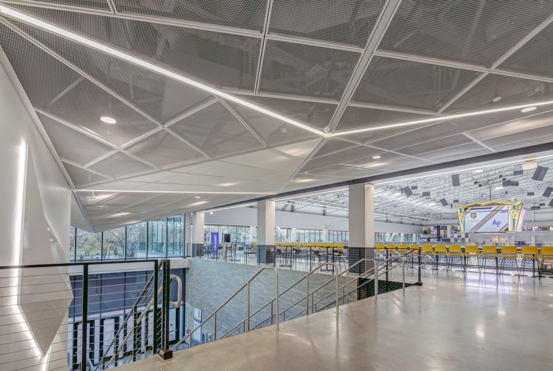 Modern interior with angular ceiling design, staircase, and open layout.