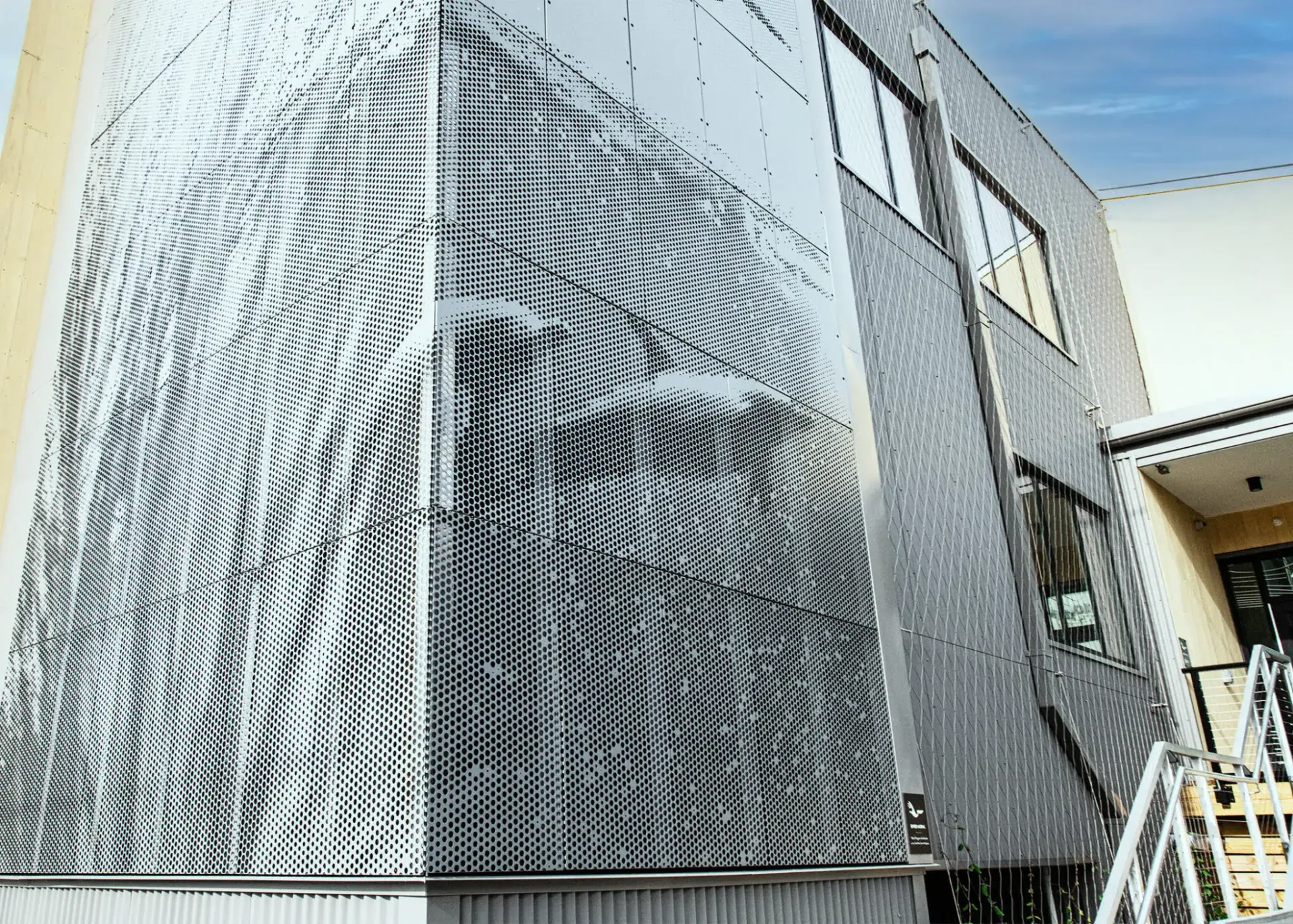 Modern building with metallic facade featuring a black and white wave-like pattern.