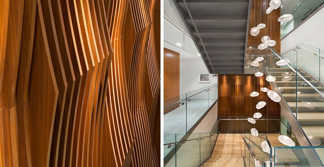 Wood paneled wall with a rippled pattern; interior hallway with stairs and sculptural elements.