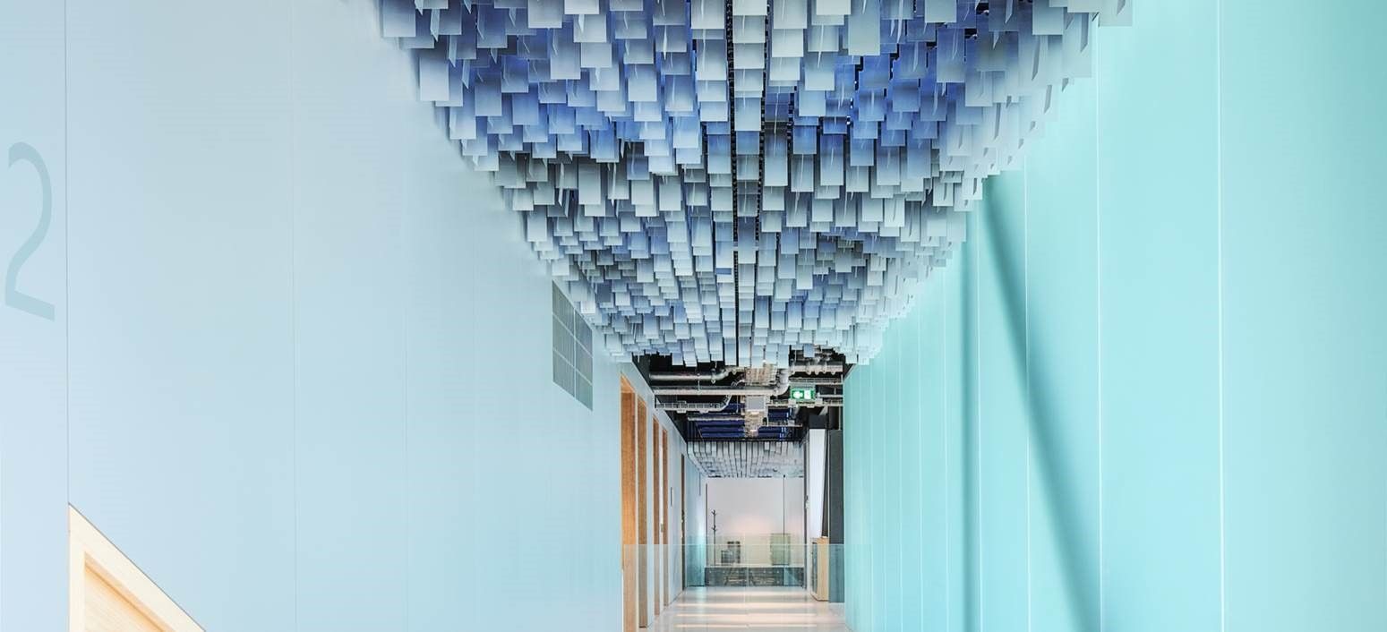 Hallway with cloud-like ceiling installation; blue and white color scheme.