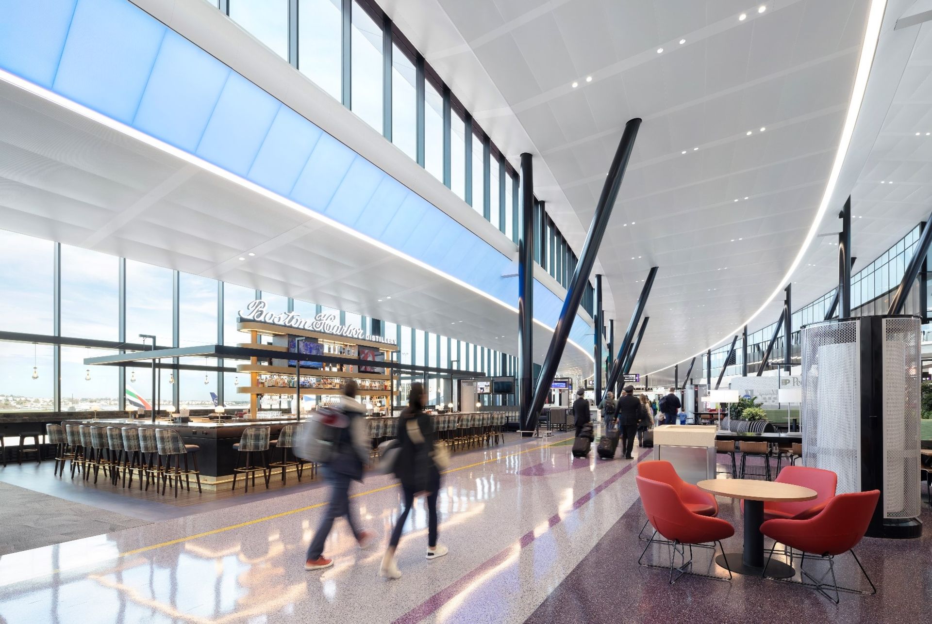 Airport interior with passengers walking, a restaurant, and large windows.
