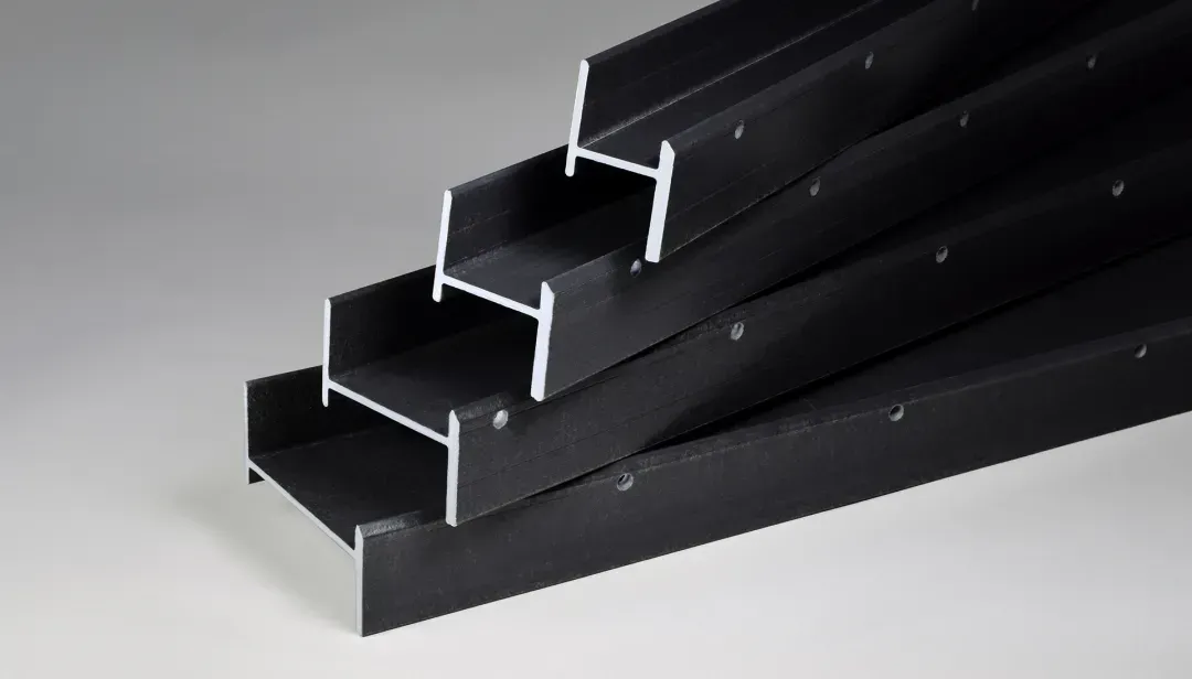 Black metal H-beams stacked, showing various sizes and shapes.