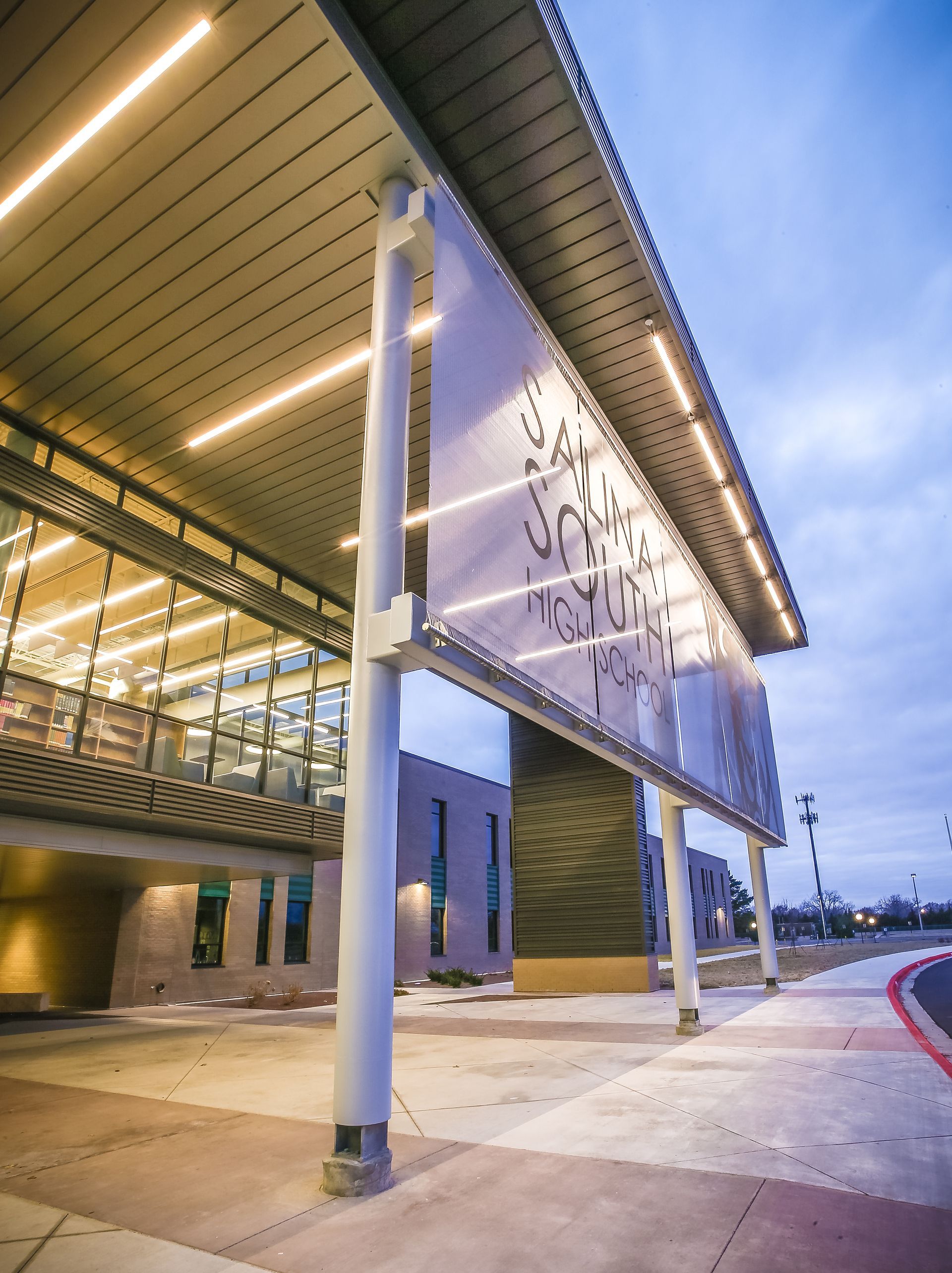Modern building exterior with decorative panel, glass windows, and illuminated canopy.