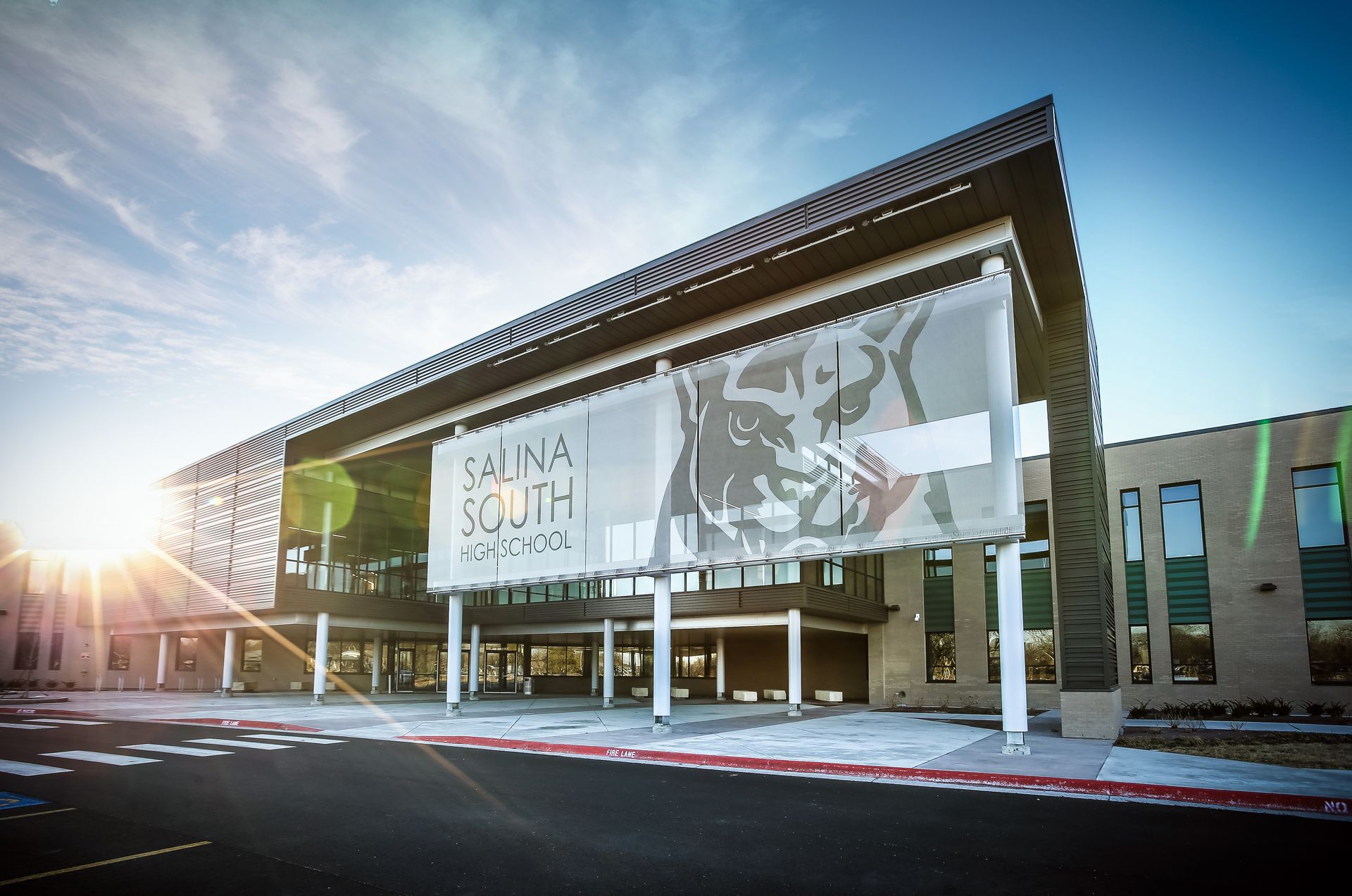 Salina South High School exterior with large sign, blue sky, and bright sunlight.