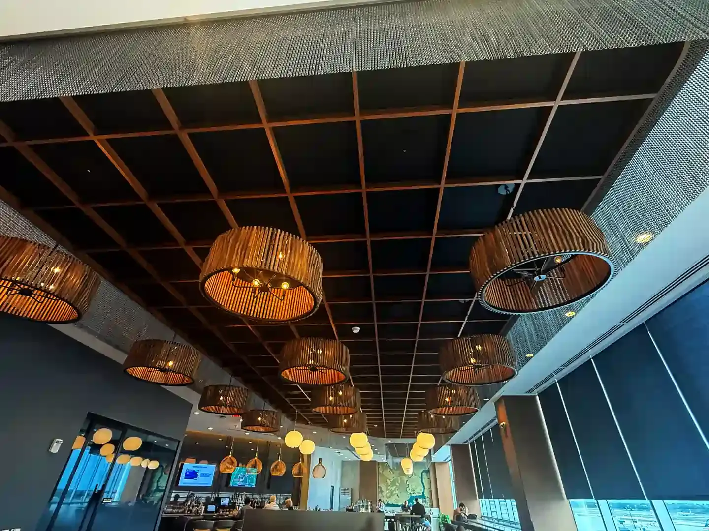 Restaurant ceiling with grid pattern and pendant lights.