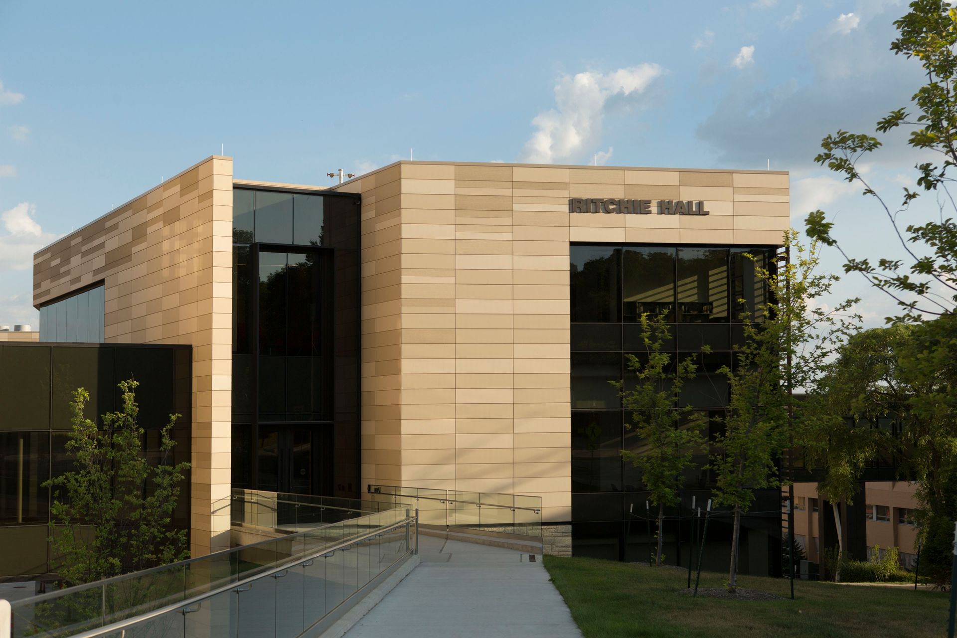 Modern beige-brick building: Baker Hall at a university, with large windows and a sloping walkway.