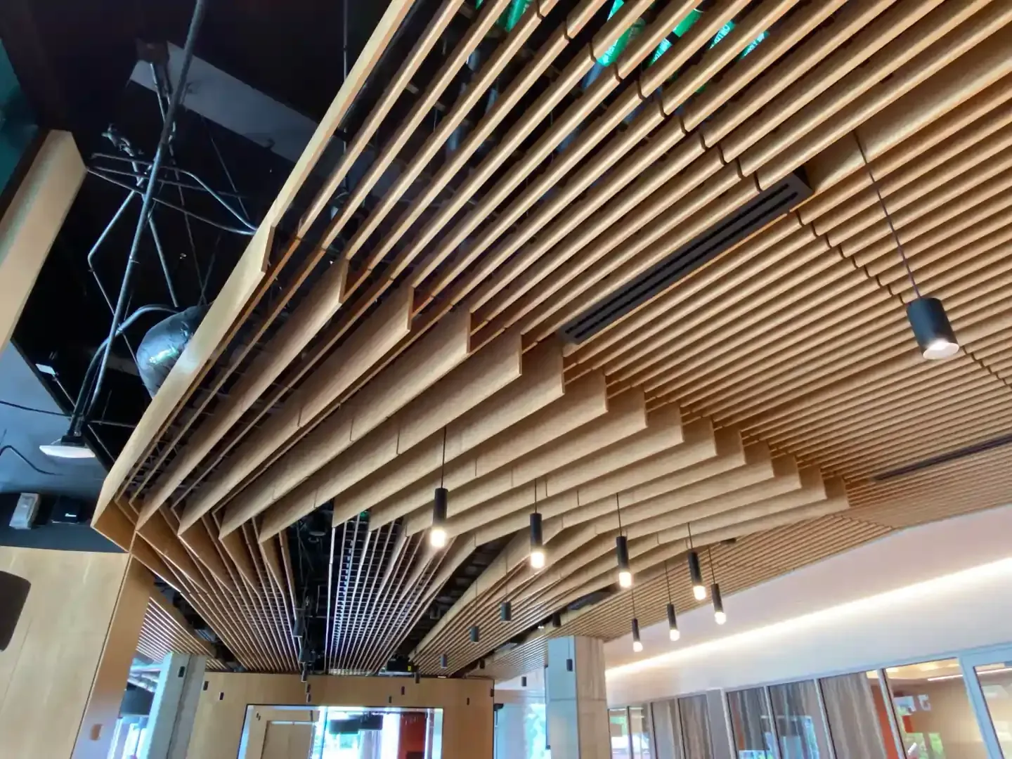 Wooden slatted ceiling with track lighting, interior view.