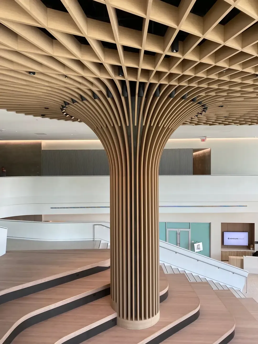 Wooden column with a latticed ceiling; interior space, steps lead up to the right.