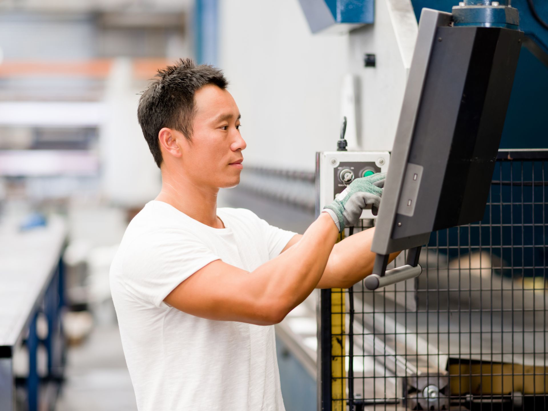 Two men in suits smiling, one signing a document at a desk with a laptop and coffee cup.