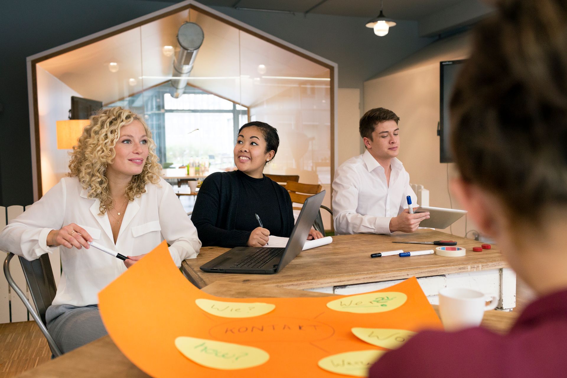 People at a table in an office, looking at a brainstorming sheet.