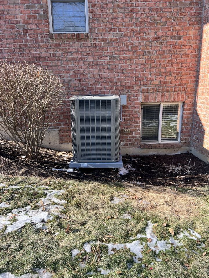 Air conditioner unit outside a brick building.