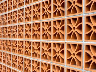 Red patterned concrete block wall, creating a decorative, open screen.