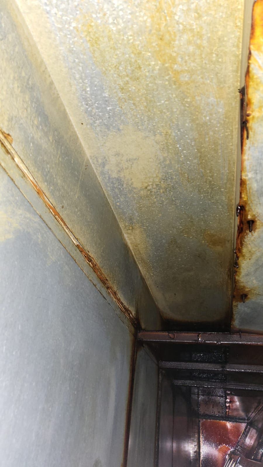 A close up of a rusty metal pipe in a room.