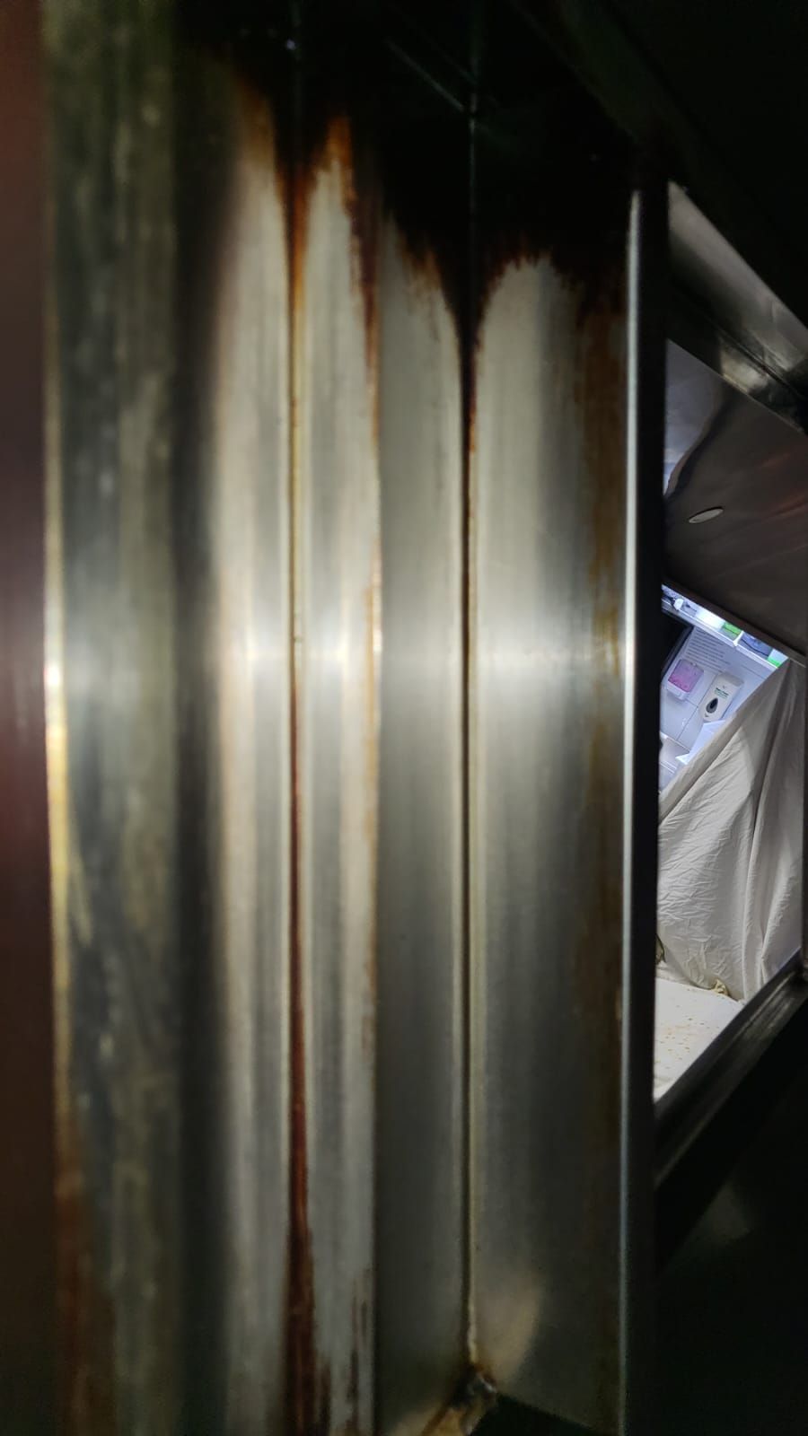 A close up of a rusty metal pipe in a room.