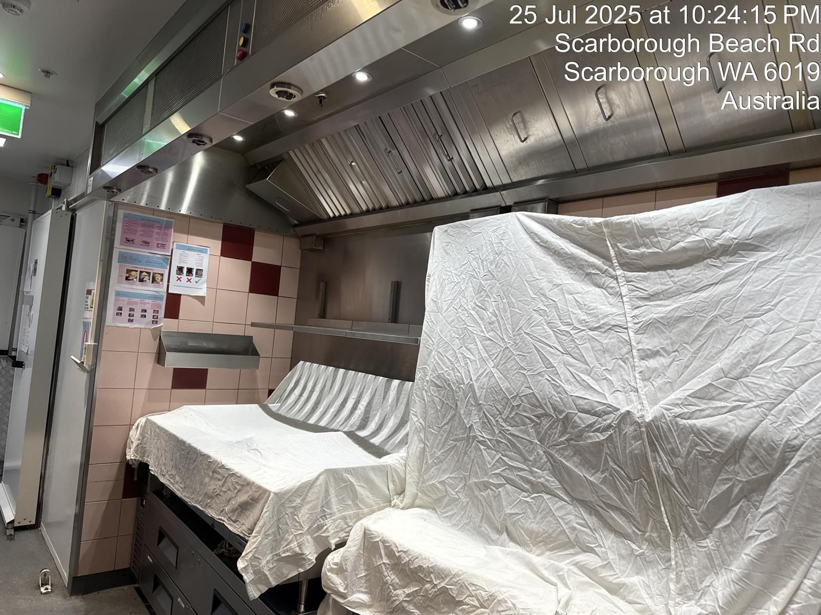 Kitchen with covered equipment and overhead ventilation. Location: Scarborough Beach Rd, Australia.