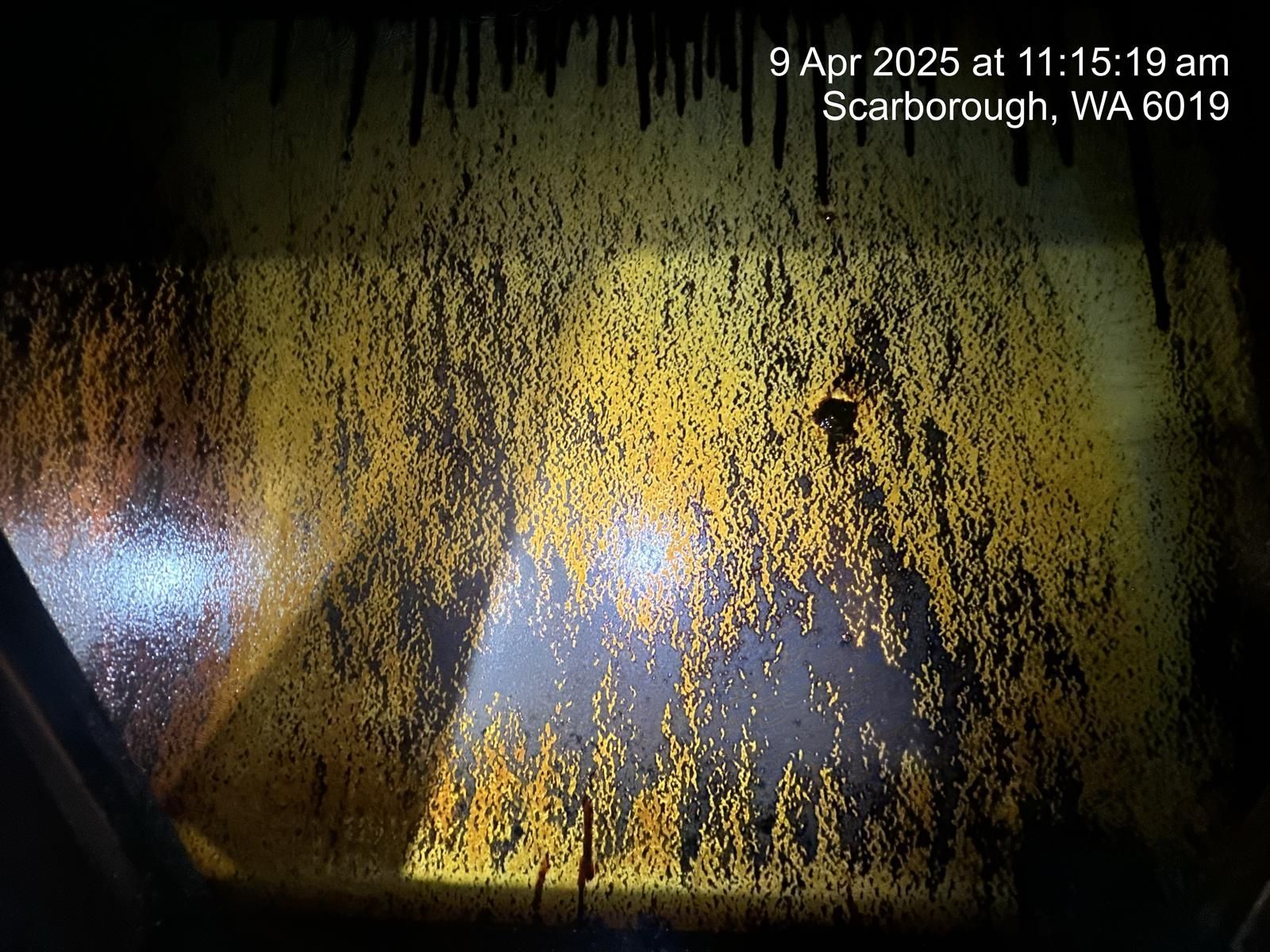 A close up of a dirty window with a light shining through it.