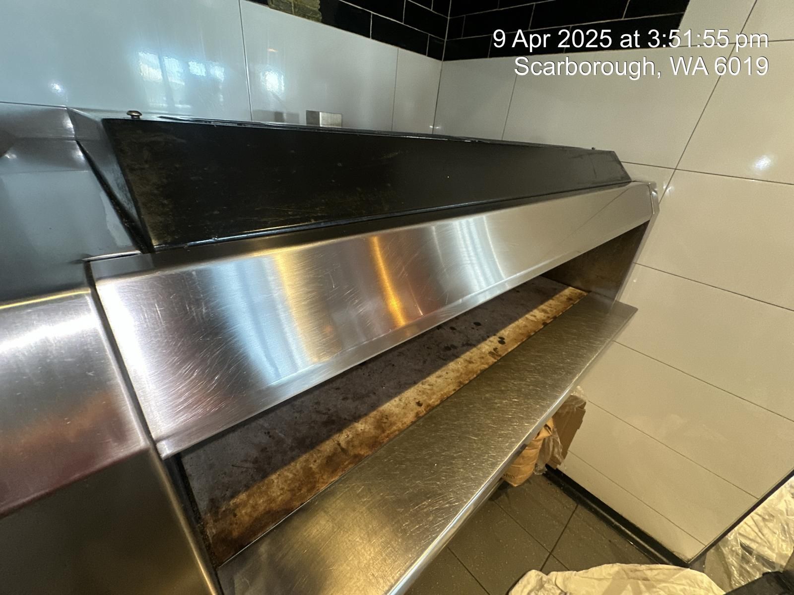 A kitchen with a stainless steel counter top and a stove top oven.