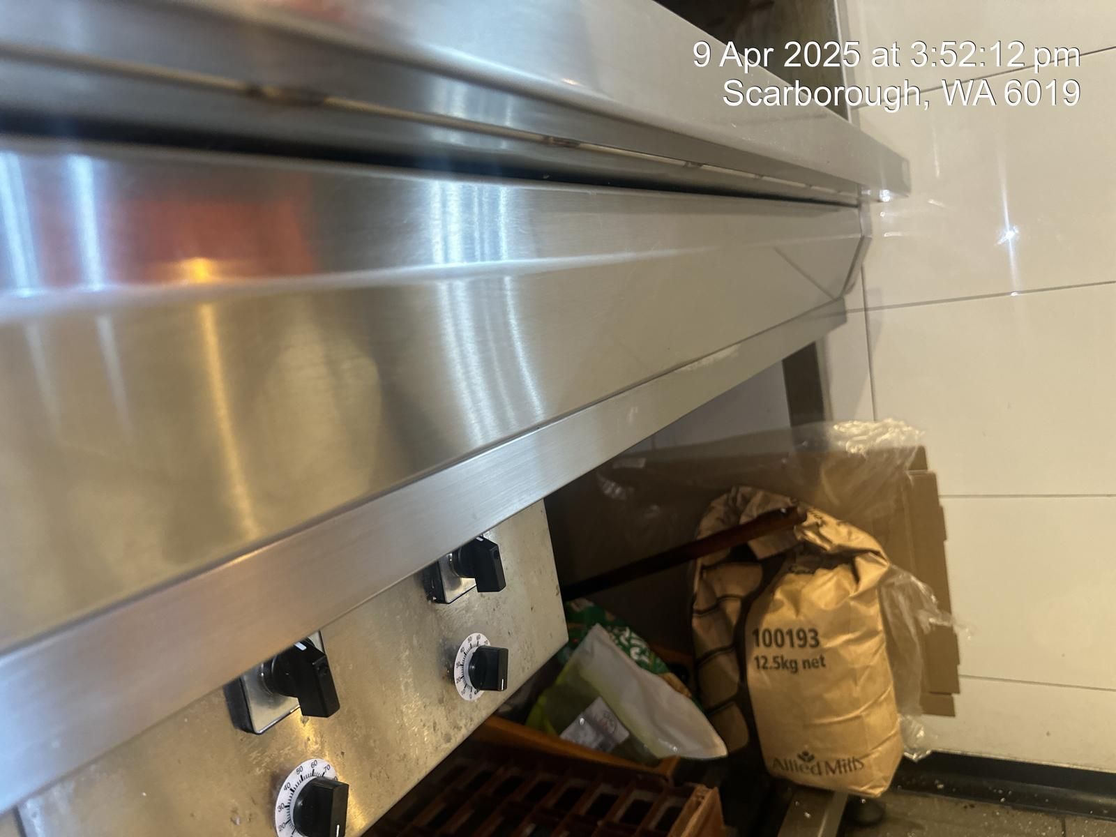 A stainless steel oven is sitting on a counter in a kitchen.