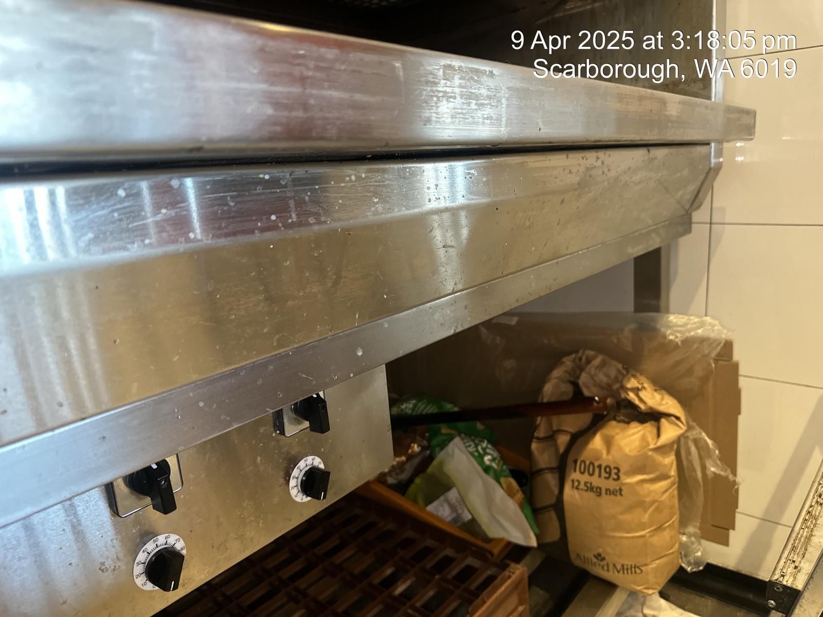 A stainless steel stove with a bag of flour next to it