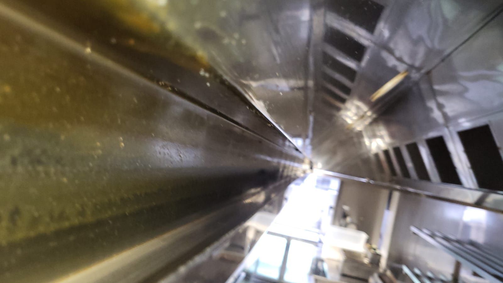 A very long stainless steel duct in a kitchen.