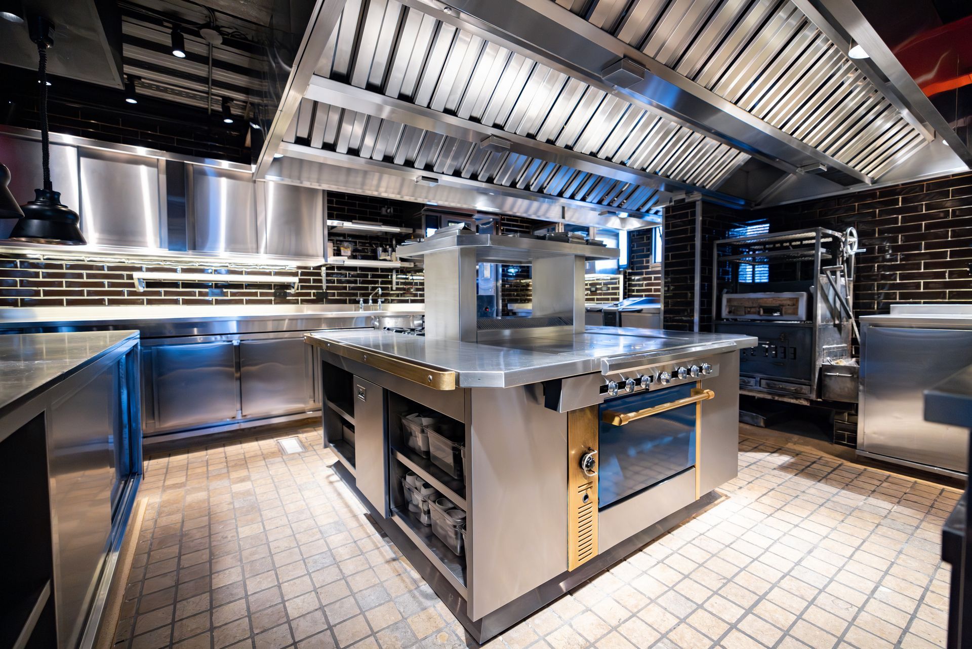 Modern commercial kitchen with stainless steel counters and appliances.