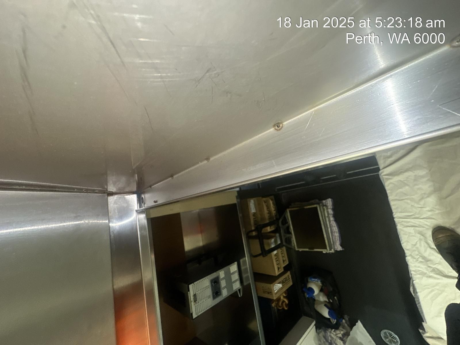 A person is standing in a room with a stainless steel wall.