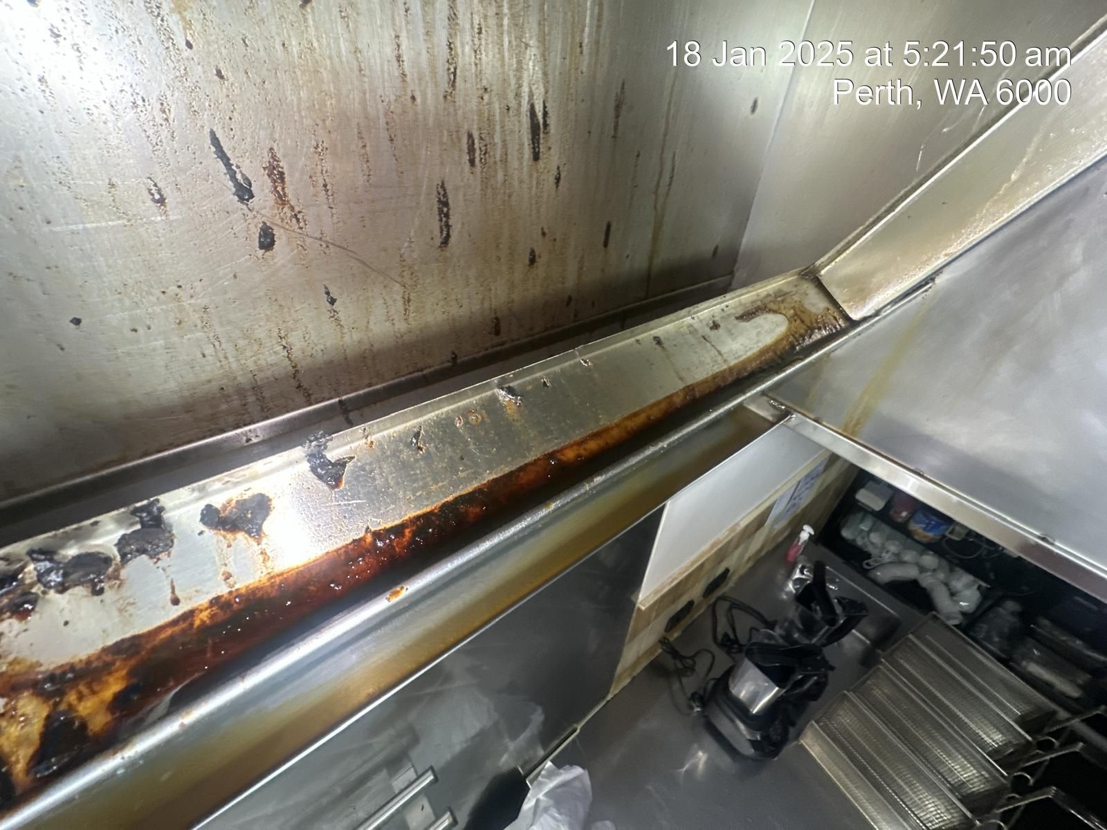 A dirty kitchen with a lot of stains on the walls and ceiling.