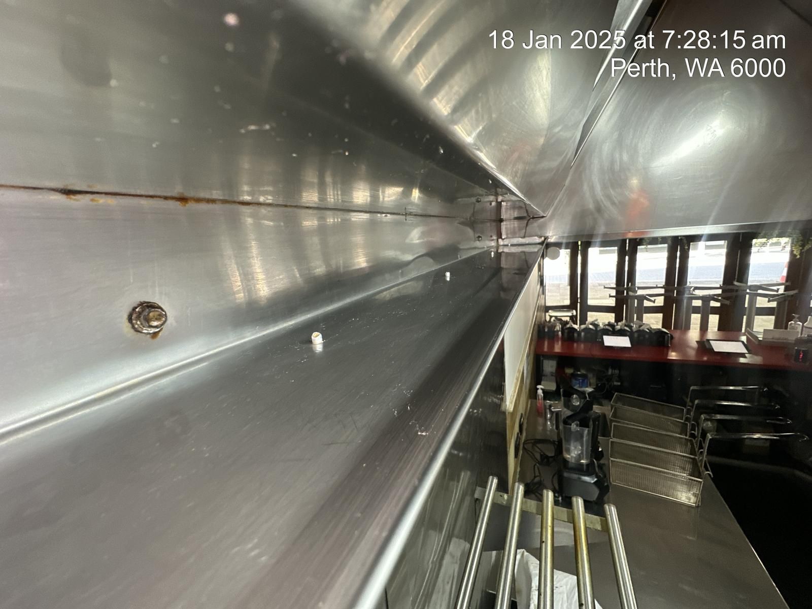 A stainless steel wall with a screw in it